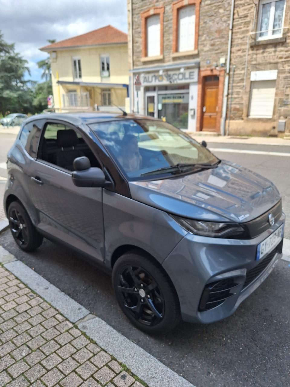 Voiturette grise garée en ville